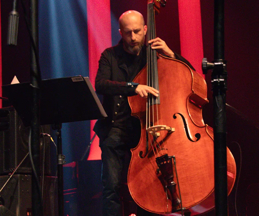 Fotografia eventowa z koncertu jazzowego, na zdjęciu mężczyzna grający na kontrabasie