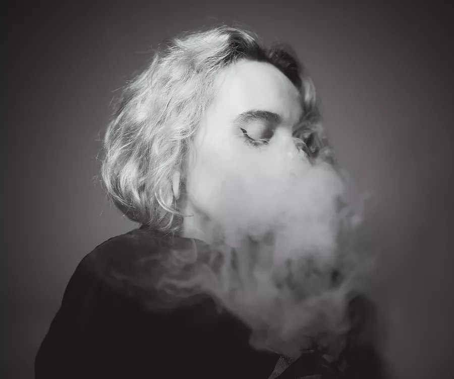 Czarnobiały portret profilu dziewczyny, twarz przysłonięta dymem