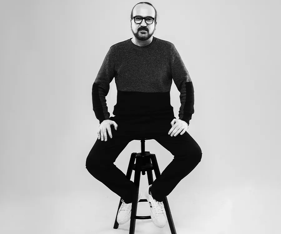 Czarnobiały portret mężczyzny siedzącego na stołku