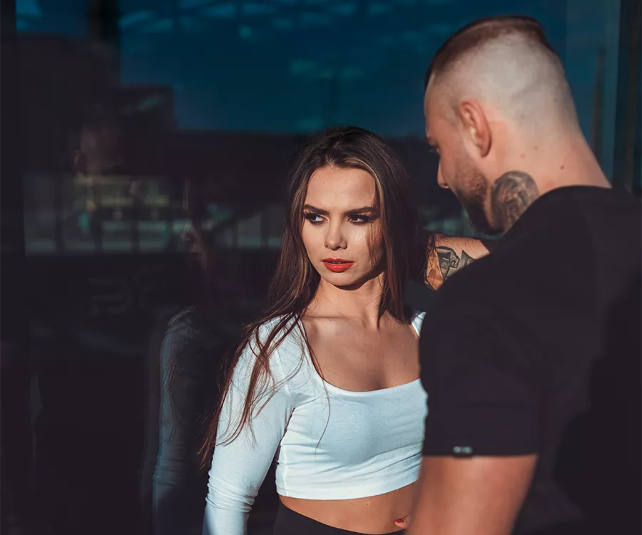 Para, mężczyzna i kobieta, stoi przed dużym szklanym oknem