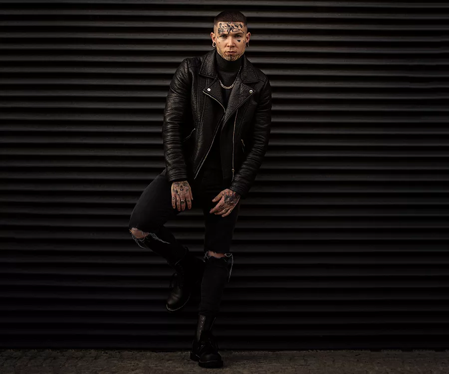 Portret mocno wytatuowanego mężczyzny w skórzanej kurtce
