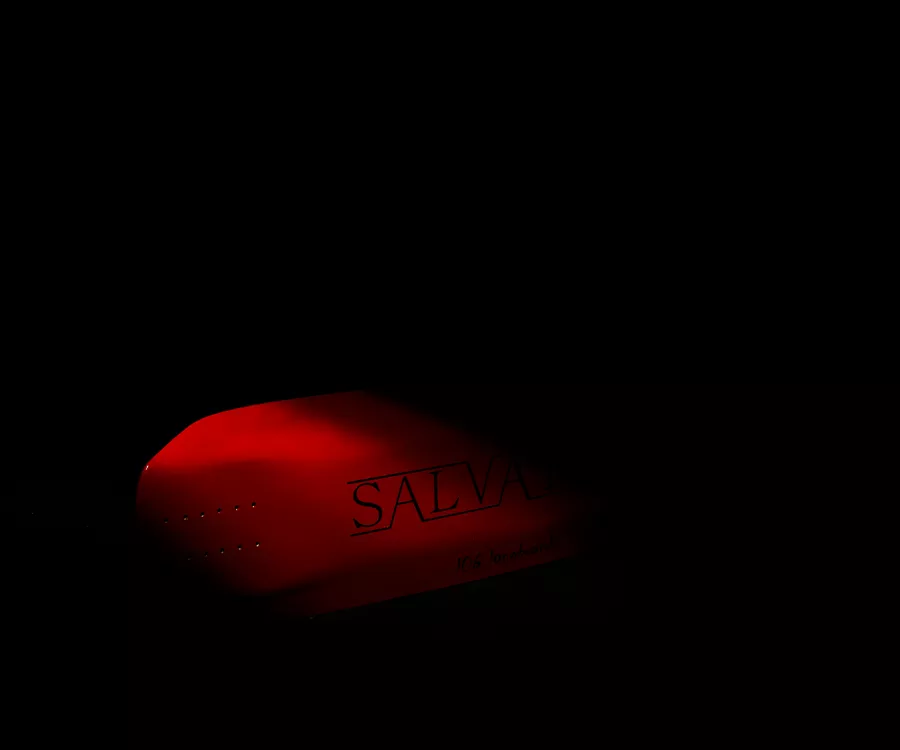 Zdjęcie produktowe przedstawiające czerwoną deskorolke częściowo wyłaniającą się z ciemności.