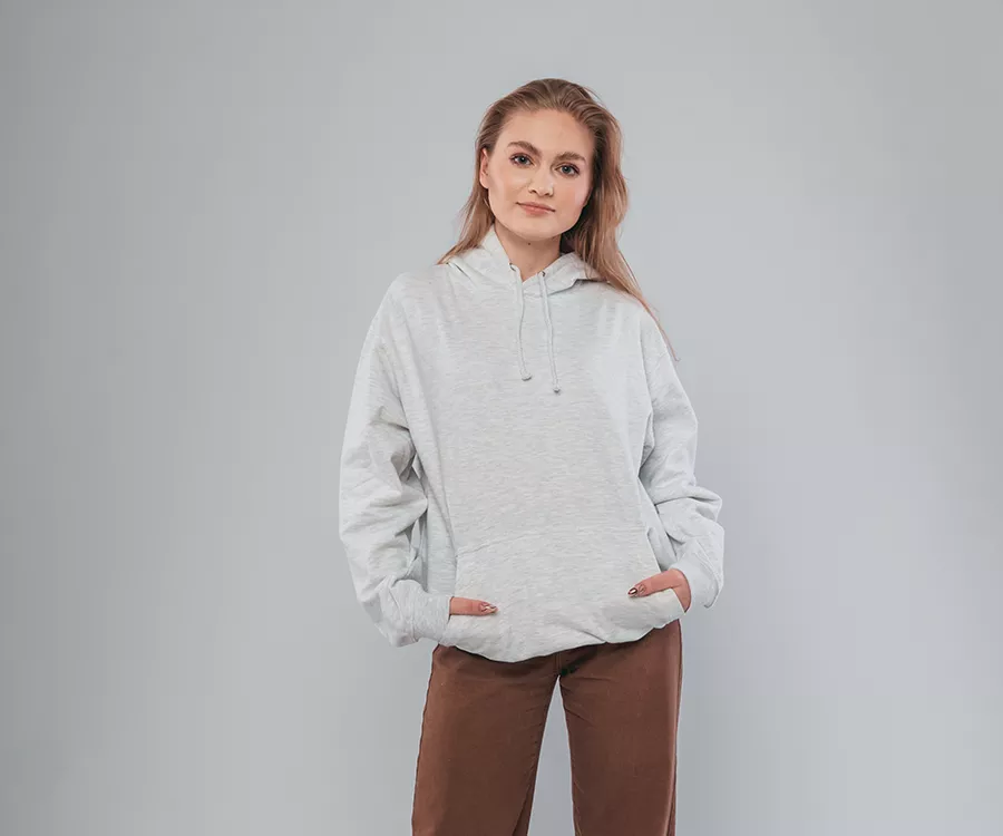 Zdjęcie produktowe przedstawiające dziewczynę pozująca w studiu na białym tle, ma ona na sobie jasną bluzę.