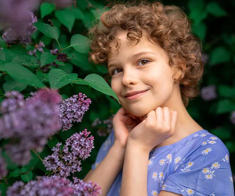 Portret dziewczynki na liściastym tle, zdjęcie wykonane w plenerze
