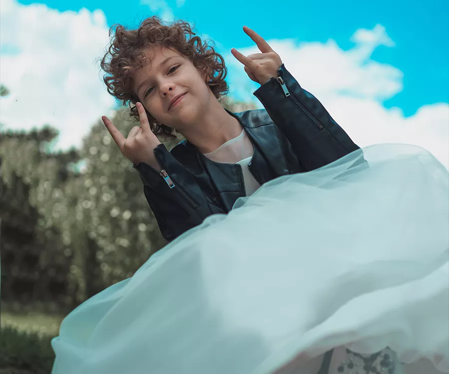 Zdjęcie dziewczynki w skórzanej kurtce i glanach oraz sukience komunijnej