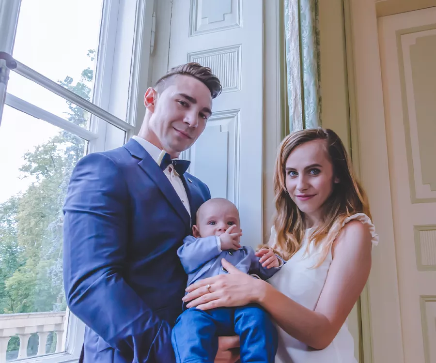 Rodzice trzymający małego chłopca, zdjęcie po chrzcie